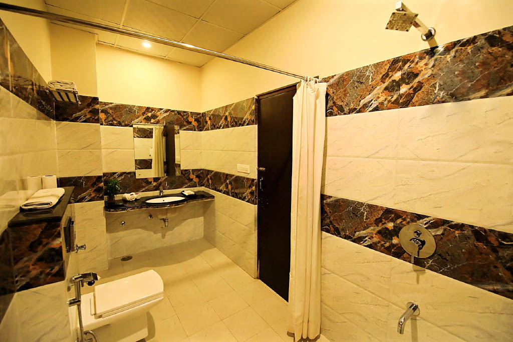 Veeva Hotel Ajmer Road Bathroom — marble finish shower